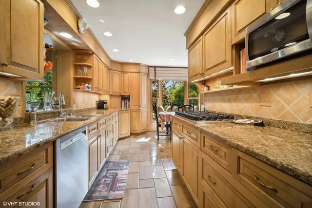 a kitchen with stainless steel appliances granite countertop a stove a sink and a microwave