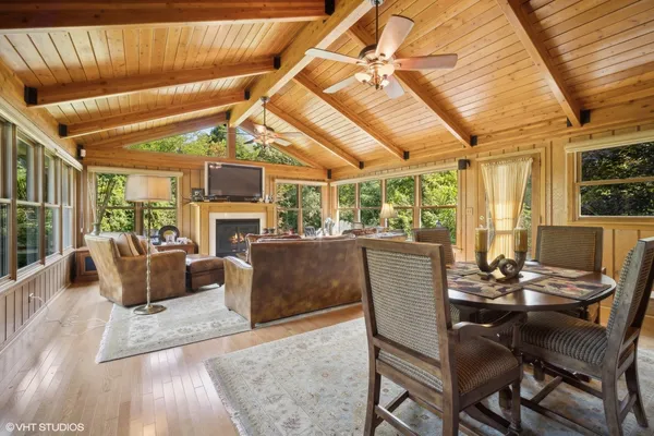 a dining room with furniture a fireplace and wooden floor