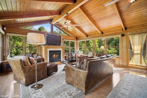 a living room with furniture a fireplace and a large window