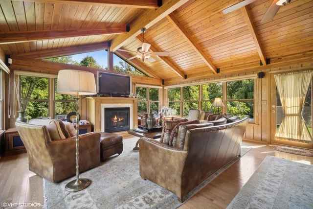 a living room with furniture a fireplace and a large window