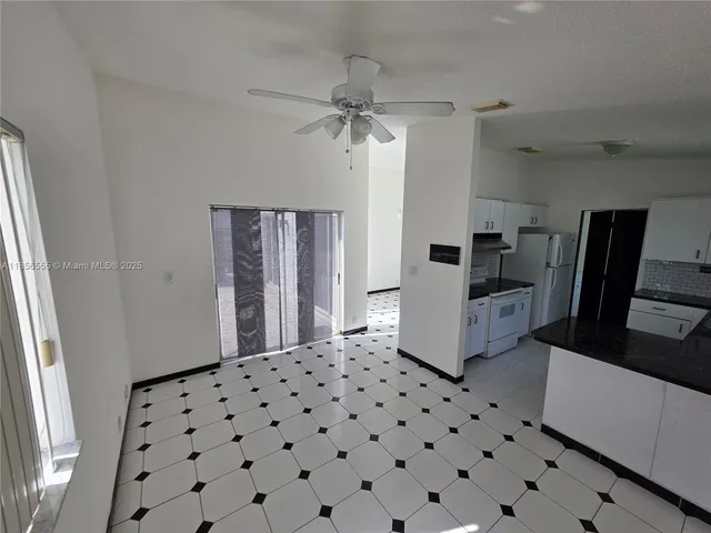 a kitchen with granite countertop a refrigerator a sink a stove and dishwasher