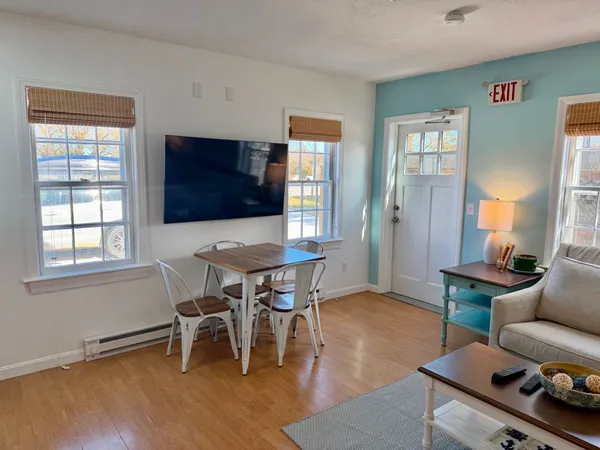 a living room with furniture a flat screen tv and a window