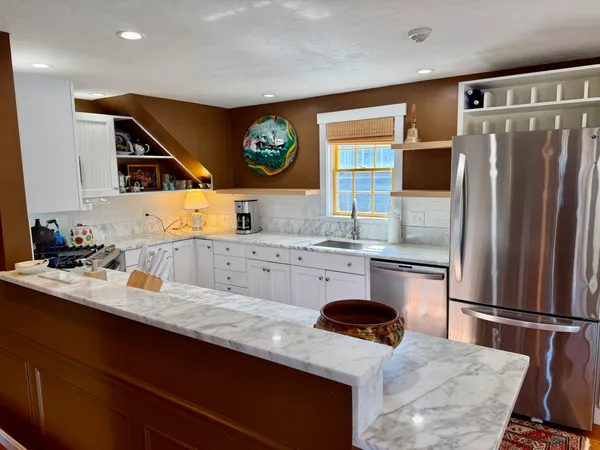 a kitchen with stainless steel appliances a stove refrigerator sink and microwave