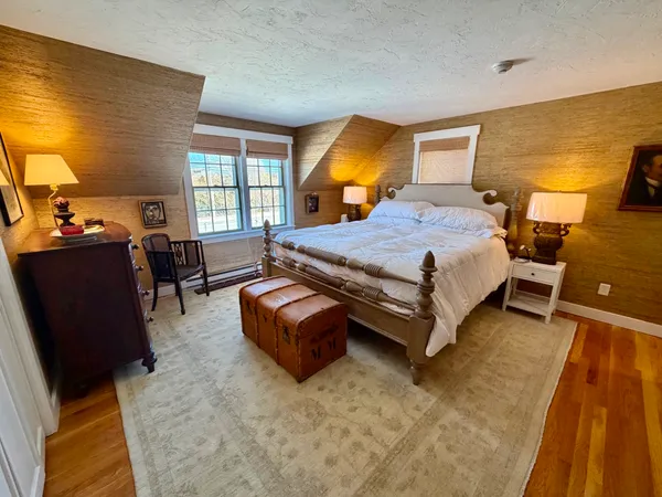 a spacious bedroom with a bed and wooden floor