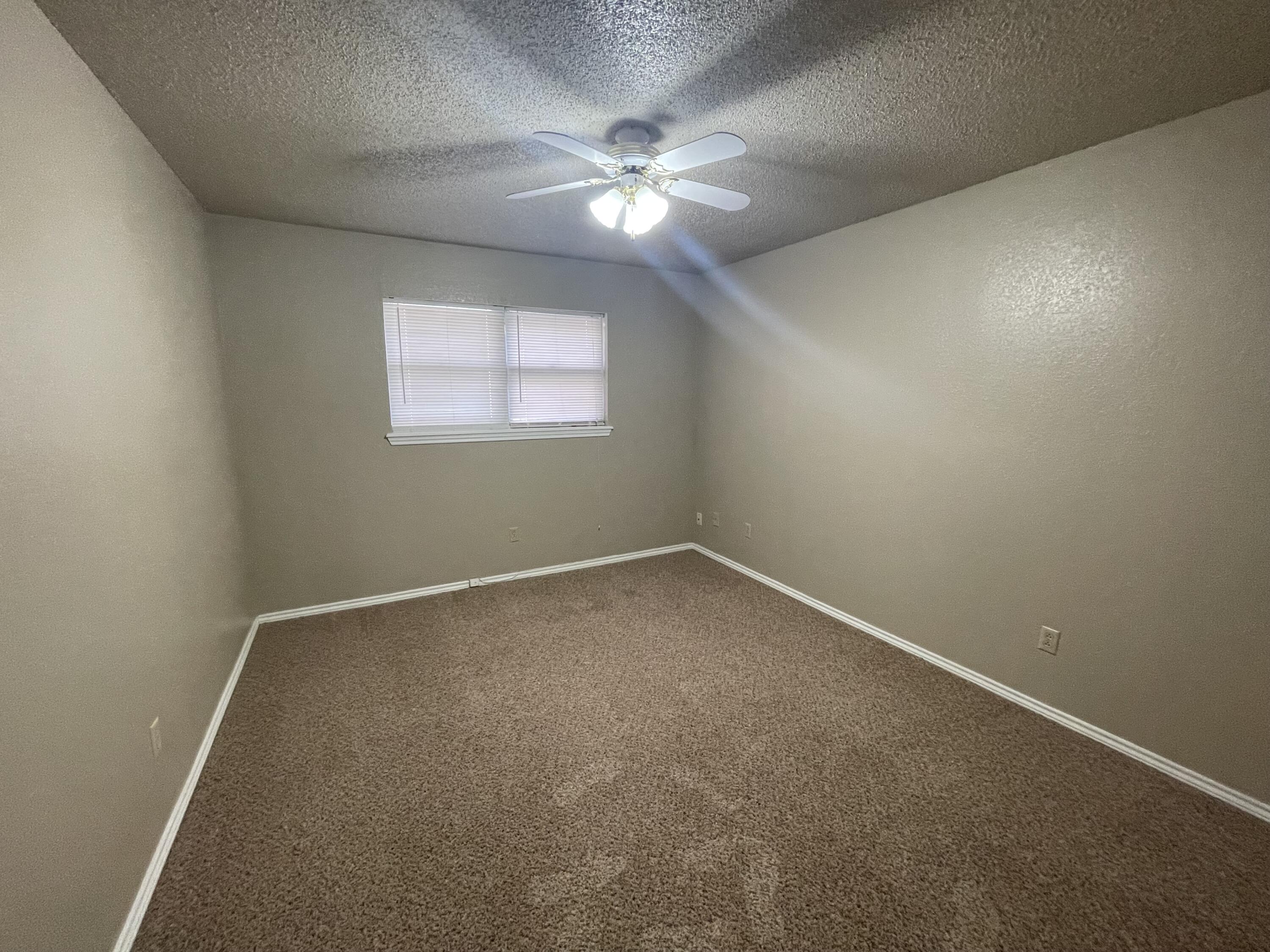 4434 78th Street Lubbock, TX 79424 - Photo 11 of 11 an empty room with a window and a fan