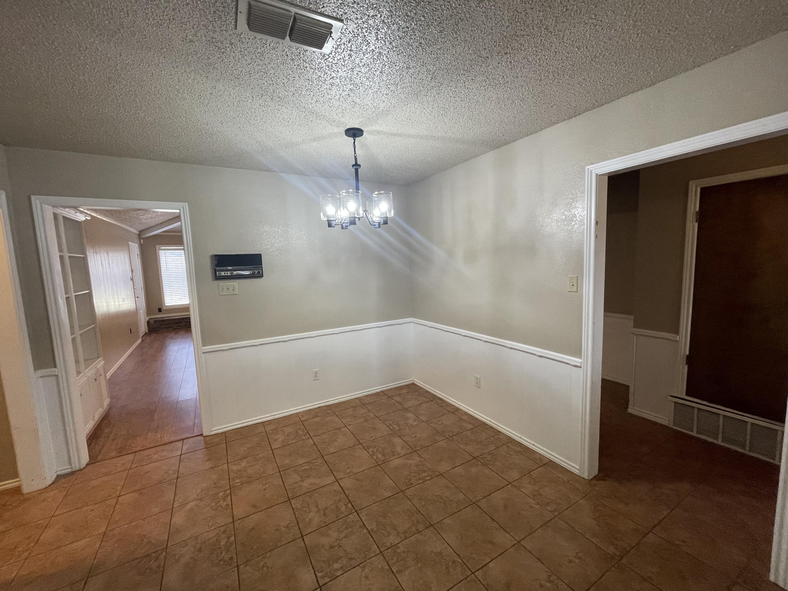 4434 78th Street Lubbock, TX 79424 - Photo 4 of 11 an empty room with fan and entrance