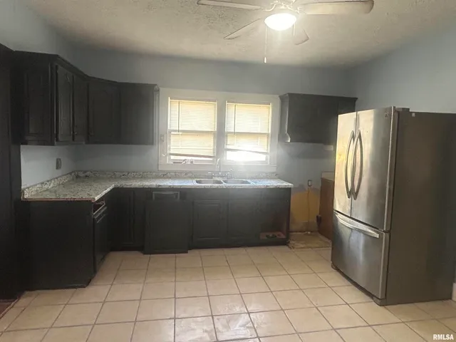 a kitchen with a refrigerator a sink and cabinets