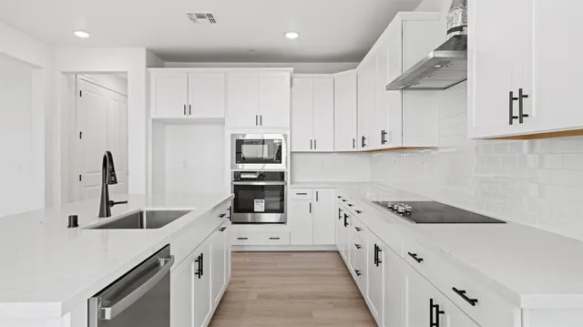 a kitchen with stainless steel appliances granite countertop a sink and cabinets