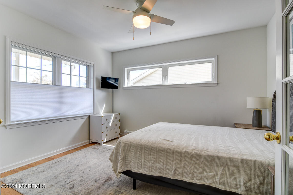212 Philadelphia Avenue Point Pleasant Beach, NJ 08742 - Photo 5 of 31 a bedroom with a bed and a chandelier