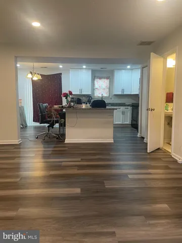 a view of kitchen with granite countertop cabinets and refrigerator