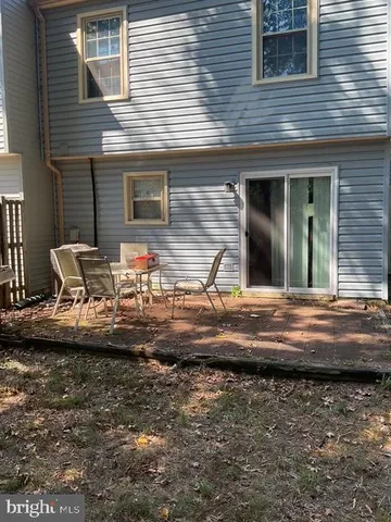 a view of a backyard with wooden fence and a large tree