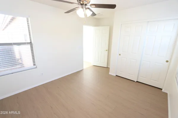 an empty room with windows and fan
