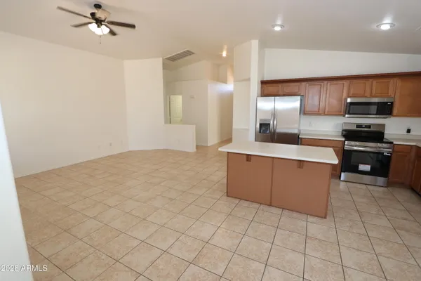 a large kitchen with stainless steel appliances a refrigerator and a stove top oven