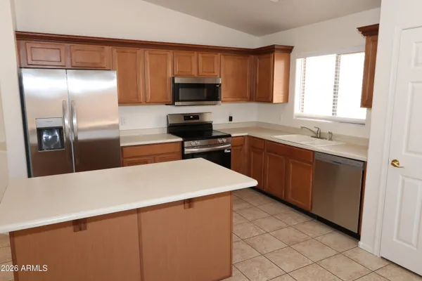 a kitchen with stainless steel appliances a refrigerator sink and microwave