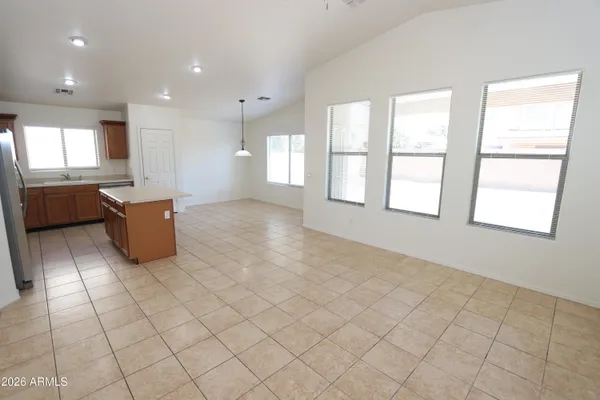 a large kitchen with white cabinets stainless steel appliances a sink and a counter top space