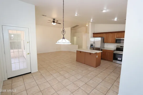 a kitchen with stainless steel appliances granite countertop a refrigerator a sink a stove top oven and cabinets
