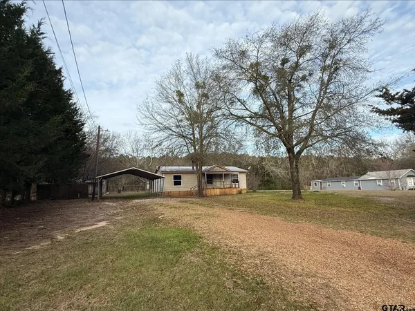 a view of a house with a yard and trees