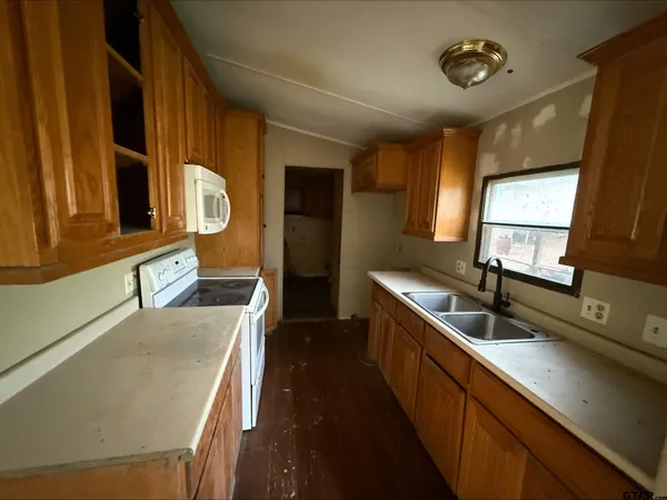 a kitchen with stainless steel appliances granite countertop a sink a stove and a refrigerator