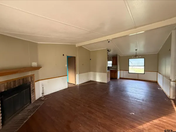 a view of a livingroom with wooden floor and a fireplace