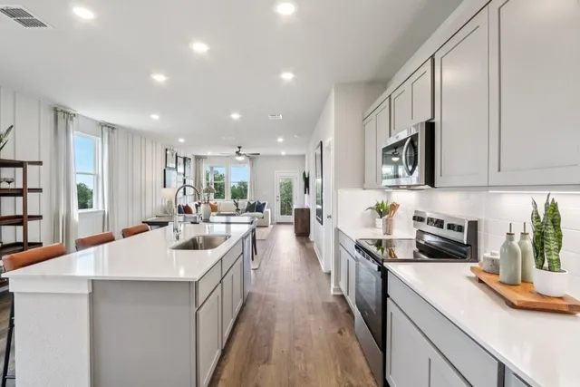 a large white kitchen with lots of counter space a sink and a large window