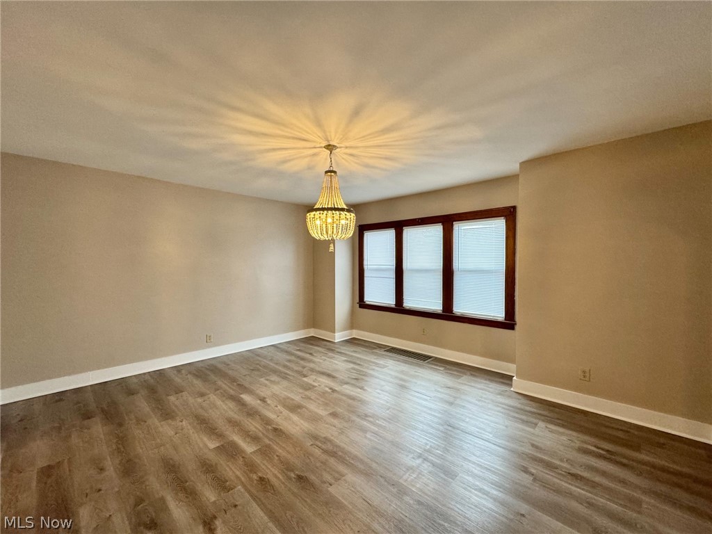 507 Canton Road Wintersville, OH 43953 - Photo 12 of 45 Empty room featuring dark hardwood / wood-style flooring and a chandelier