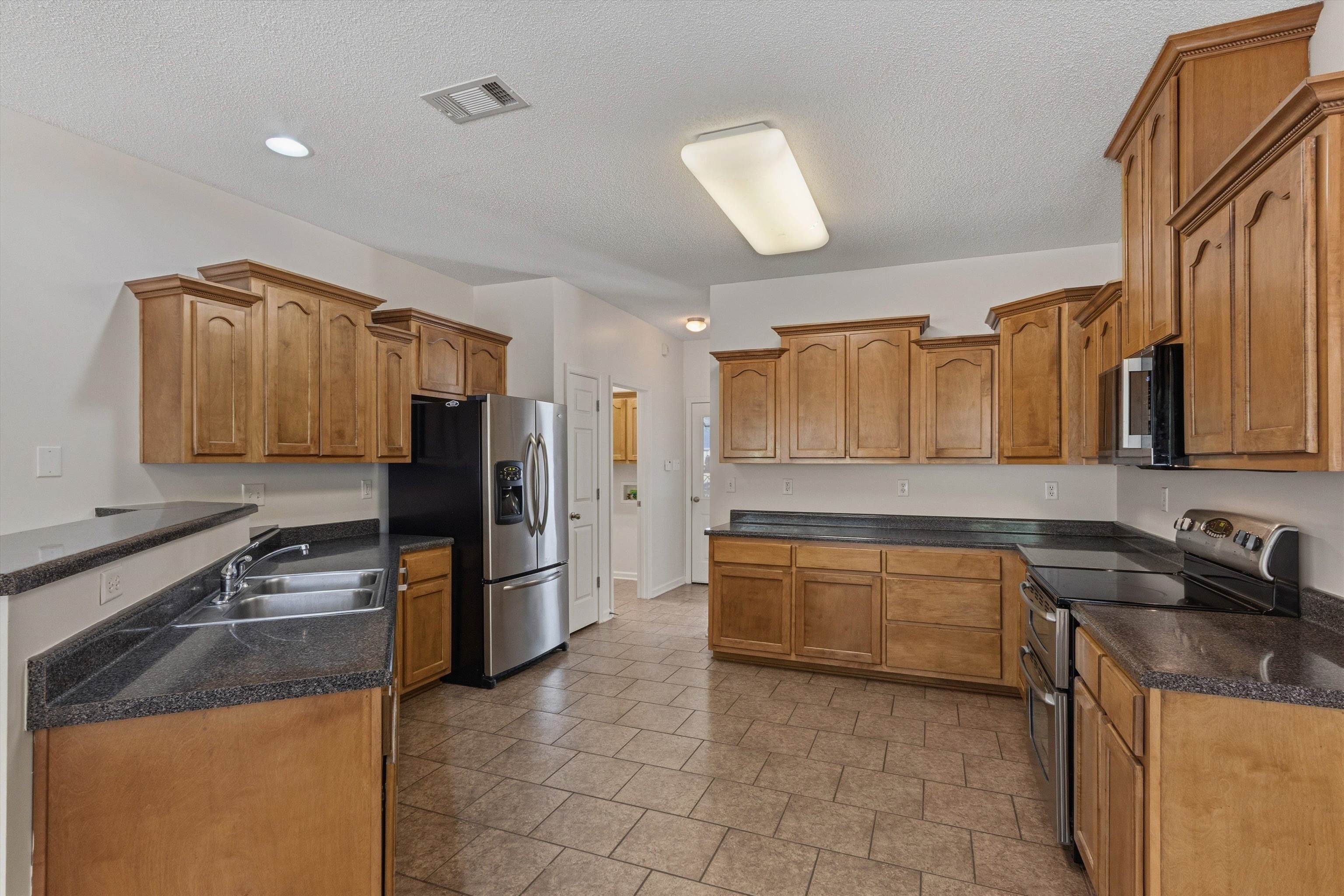 3671 Haynes Road Bartlett, TN 38133 - Photo 16 of 40 a kitchen with a sink a stove and refrigerator