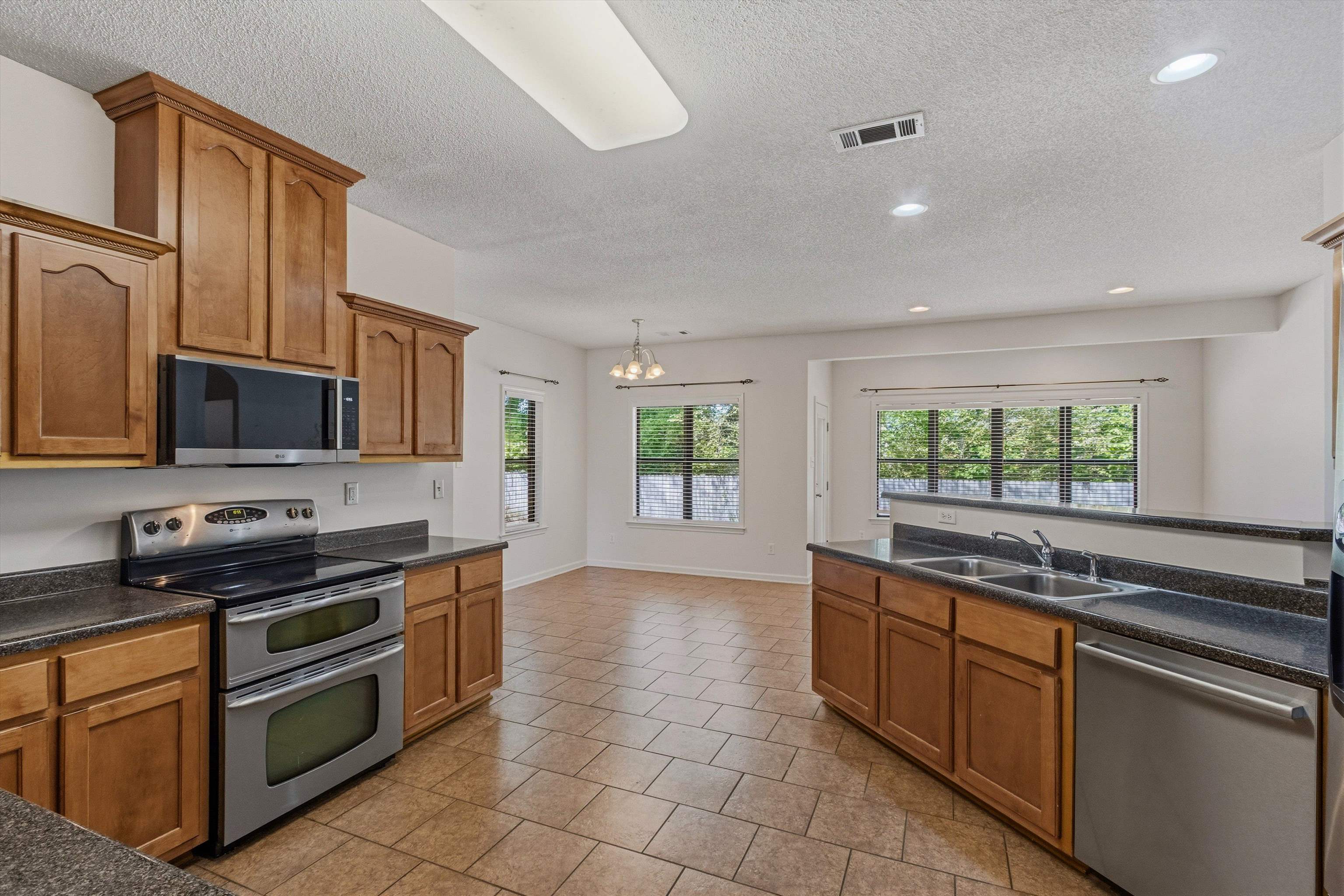 3671 Haynes Road Bartlett, TN 38133 - Photo 17 of 40 a kitchen with stainless steel appliances a stove sink and microwave