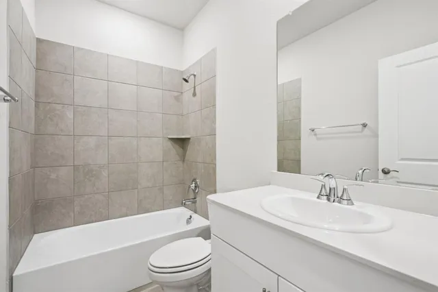 a bathroom with a sink a toilet a mirror a bathtub and shower