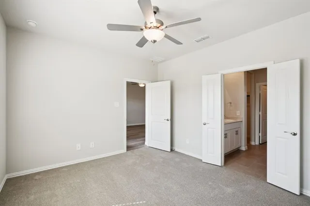 a view of an empty room with a ceiling fan