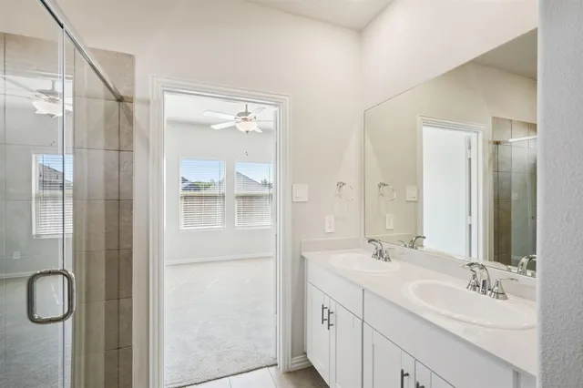 a bathroom with a double vanity sink mirror and shower
