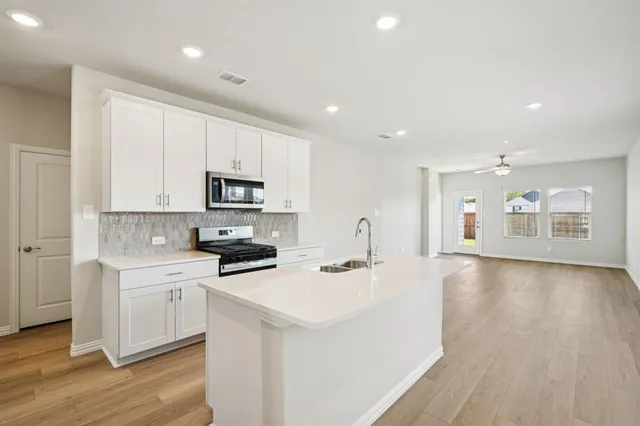 a kitchen with a sink a stove and cabinets