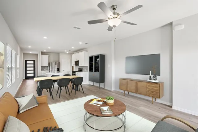 a living room with furniture a dining table and a chandelier
