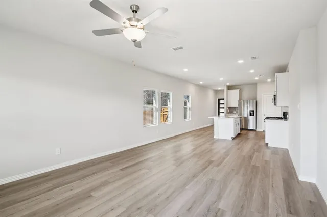 a view of kitchen with refrigerator microwave and wooden floor