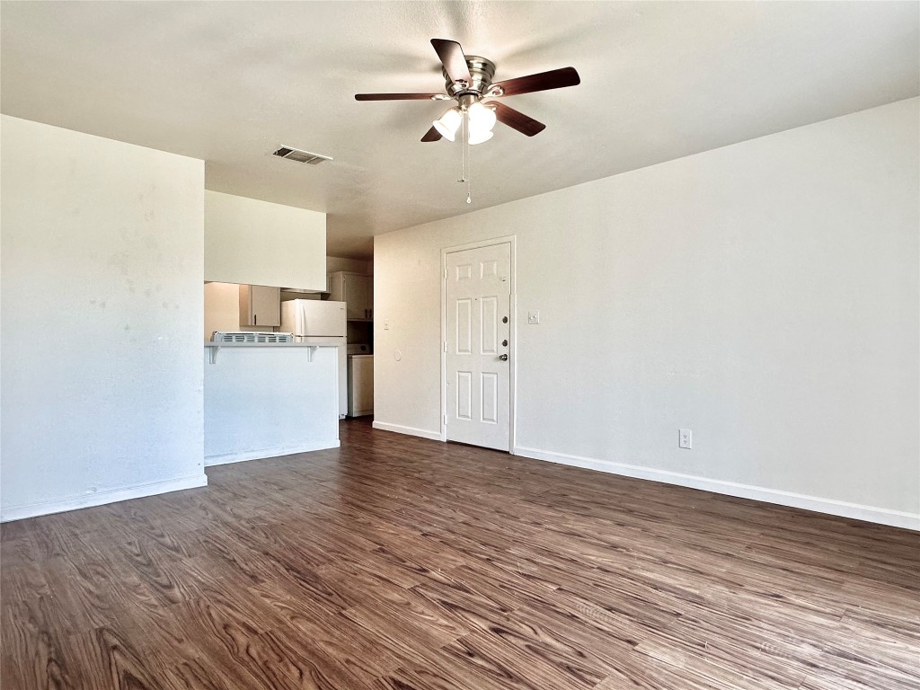 a view of a kitchen with wooden floor and a ceiling fan