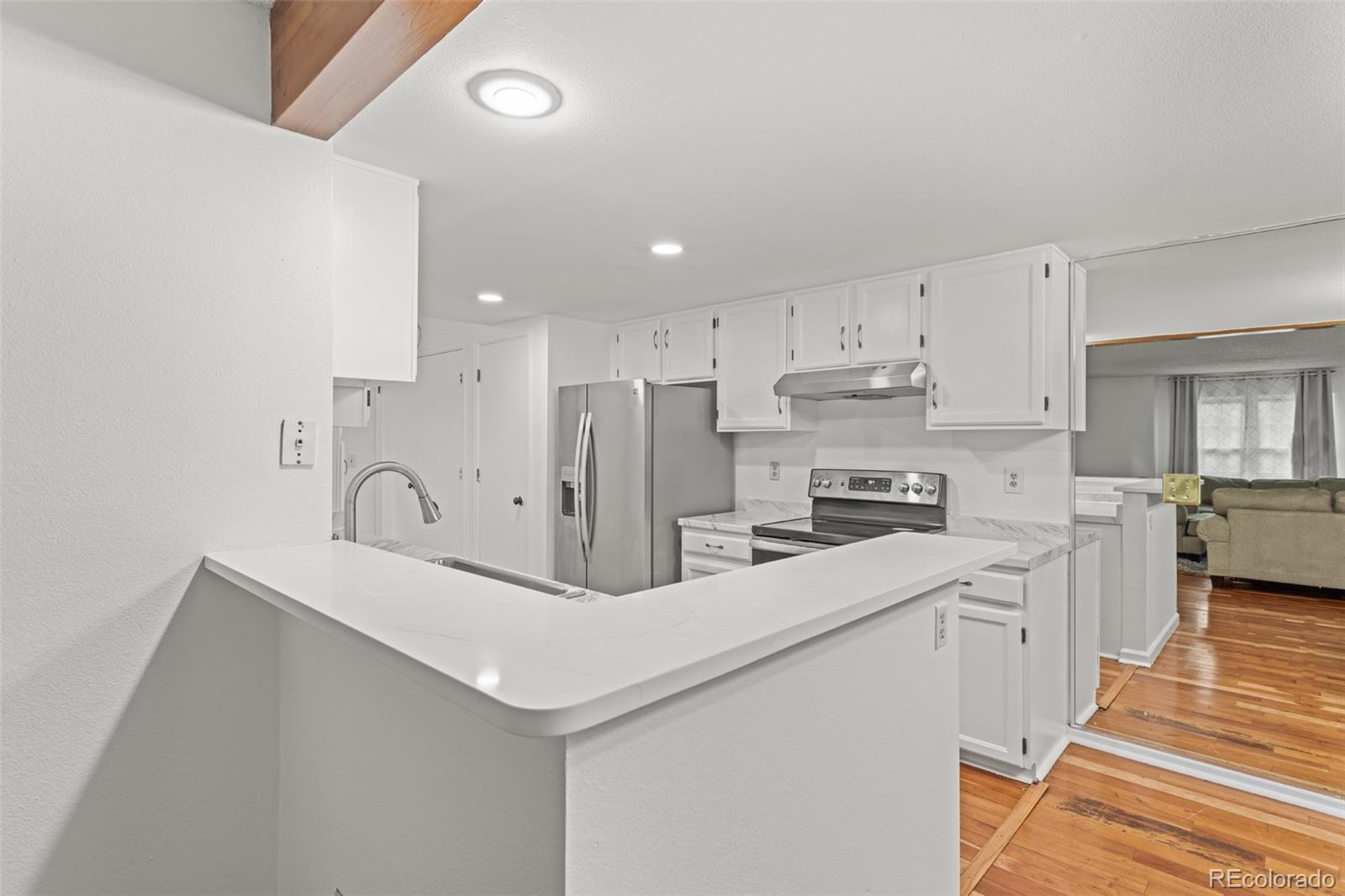 1720 South Quintero Way Aurora, CO 80017 - Photo 7 of 21 a kitchen with stainless steel appliances a sink a stove a refrigerator and cabinets