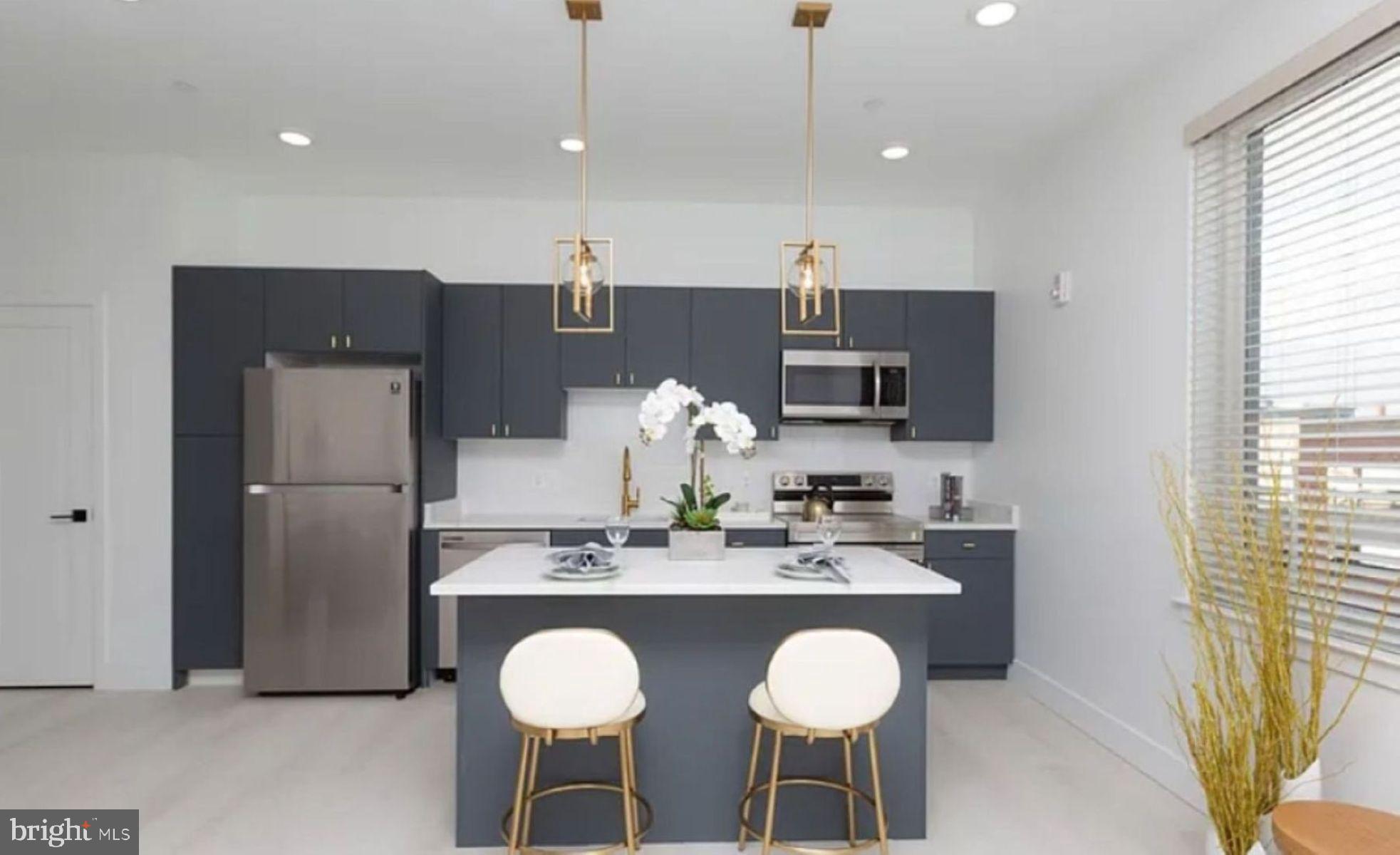 a kitchen with stainless steel appliances granite countertop a sink and a refrigerator
