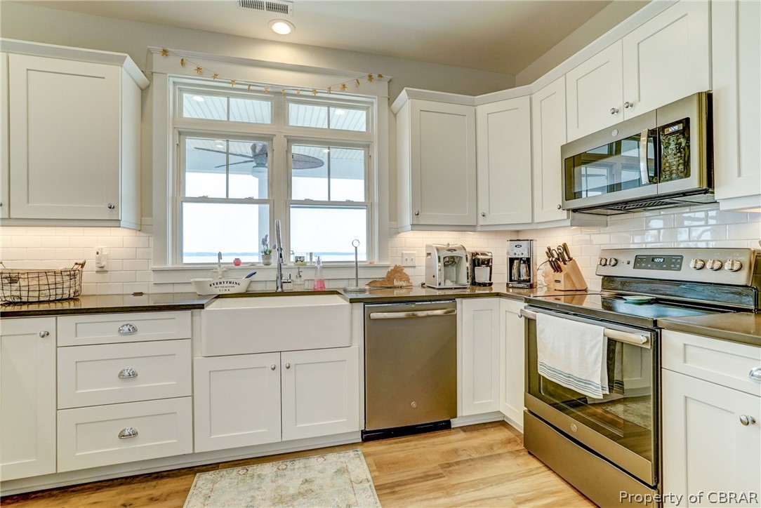 1237 Little Florida Road Farnham, VA 22460 - Photo 31 of 50 a kitchen with granite countertop white cabinets stainless steel appliances a sink and a window