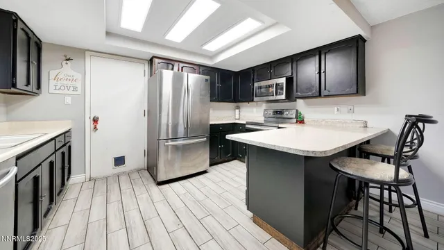a kitchen with stainless steel appliances a sink cabinets and wooden floor