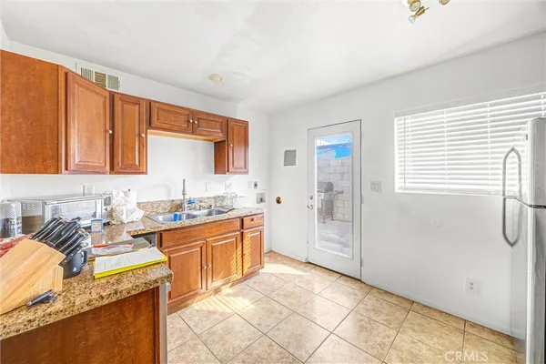 a kitchen with granite countertop a sink stove and cabinets