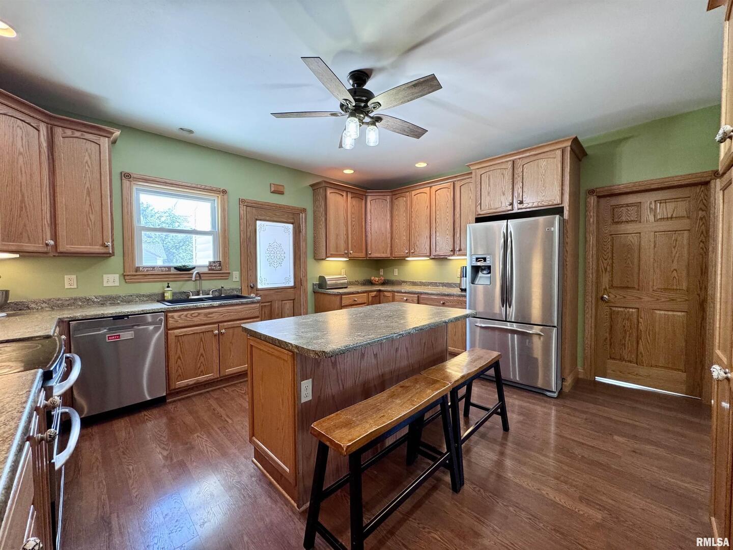 1415 4th Street Fulton, IL 61252 - Photo 33 of 58 a kitchen with granite countertop a refrigerator a sink dishwasher a stove and white countertops with wooden floor