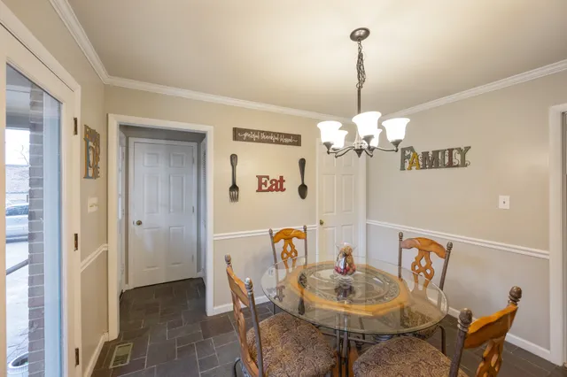 a view of a dining room with furniture and chandelier