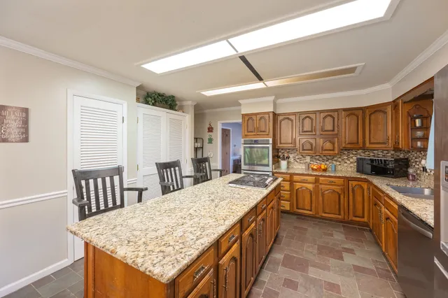 a large kitchen with kitchen island a sink table and chairs