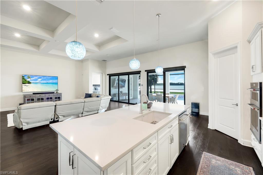 19696 Aqua View Lane Fort Myers, FL 33913 - Photo 13 of 49 a large white kitchen with a stove a sink a refrigerator and a dining table with wooden floor