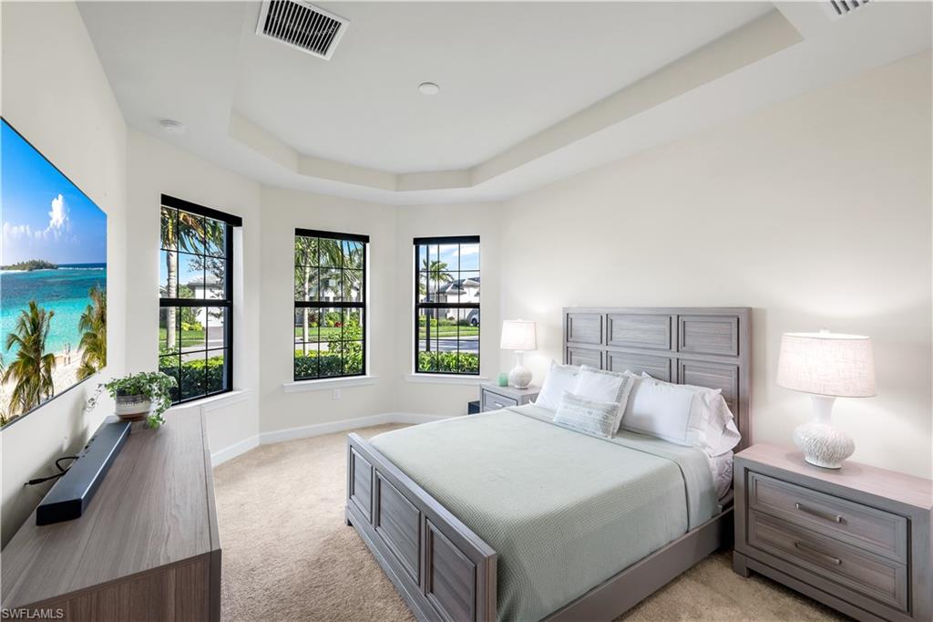 19696 Aqua View Lane Fort Myers, FL 33913 - Photo 21 of 49 a bedroom with a large bed and a flat tv screen on dresser