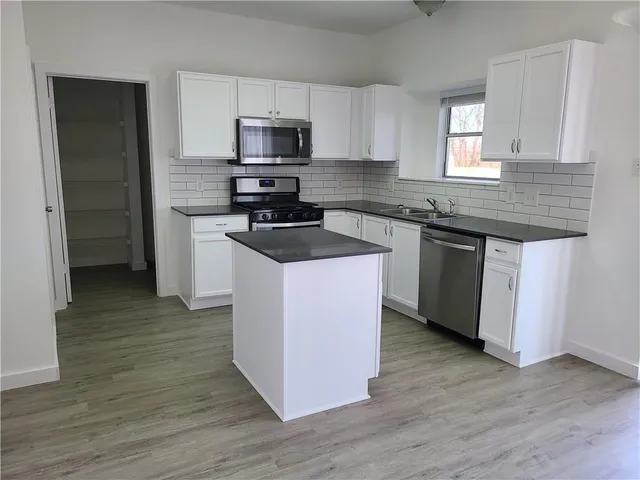 a kitchen with wooden cabinets and stainless steel appliances