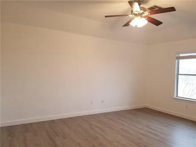 an empty room with a window and a fan