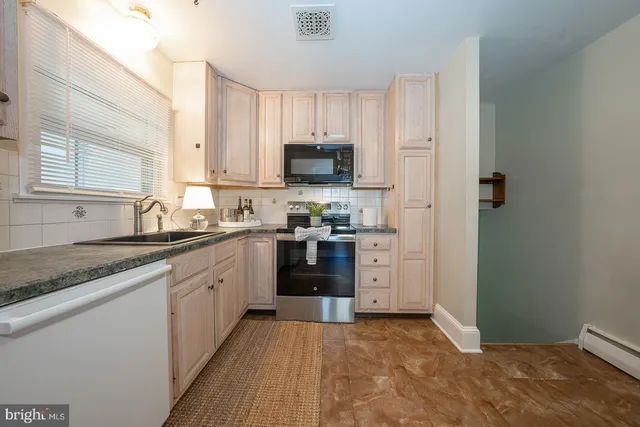 a kitchen with granite countertop white cabinets and stainless steel appliances