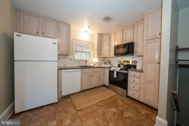 a kitchen with white cabinets and white appliances