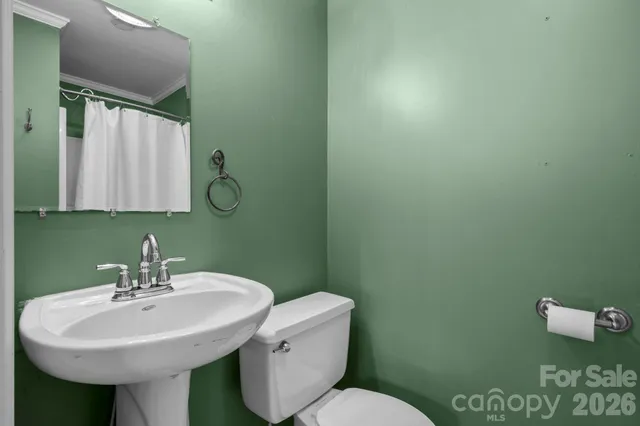 a bathroom with a sink a toilet and mirror