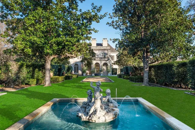 a view of a fountain in a yard with palm trees